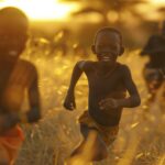 A playful image of African happy children racing through a sun-drenched savanna, their carefree laughter and joyful shouts echoing across the golden grasslands as they play games of tag and hide-and-seek amidst the natural beauty of their homeland. kodak portra 800, soft light, film aesthetic, full hd, 8k, canon R6 Mark 2, 135mm lens, realistic photo --ar 3:2 --style raw Job ID: 25a955f4-8cfd-4be5-a854-c558577c5671